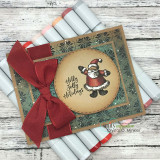 Kraft card with a Santa ornament in a snowflake circle, tied with a red bow on rolled paper.