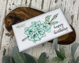 Slimline sample card with the gladiolus colored soft mint green on a white scalloped panel stamped 'happy birthday' in script, styled on a wooden board.