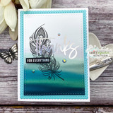 Handmade sample card made with the By the Sea papers — a stamped feather over a teal-to-seafoam ocean-gradient background inside a blue scalloped frame, with a butterfly accent on a rustic wood surface.