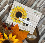Card with the sunflower colored bright yellow, 'blessed grateful loved,' beside fall leaves.