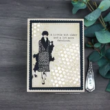 Cream card with the number background in soft grey behind a stamped woman in a coat, beside a panel reading A little bit older and a lot more fabulous.
