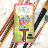 Slimline card with the flower filled paintbrush colored in pink, yellow and purple, popped up on a lime green grid background with the Frida Kahlo sentiment stamped at the top and a tiny 'happy thoughts' label at the base.
