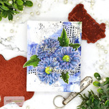 Blue asters over a blue and black mixed-media collage with 'hugs & kisses' in script, shown with the red rubber stamp.