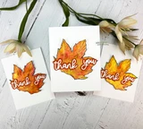 Three white cards with orange and yellow maple leaves and layered thank you die cuts.