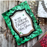 Green foliage-framed Christmas card with the 'We wish you a Merry Christmas' sentiment centered in white.