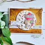 Rustic card with a bundled-up owl in a circle over the snowflake background on wood grain.