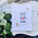 White textured card with a circle window: the owl in a blue hat with a red mug above “just a ray of SUNSHINE.”