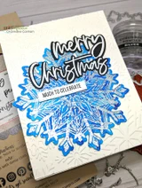 Card using the Heart of Christmas dies, 'merry Christmas' over a blue snowflake with 'much to celebrate.'