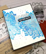 Card made with the Heart of Christmas dies, 'peace' and 'good tidings and joy' over a silver snowflake.