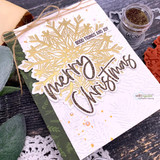 Card using the Heart of Christmas dies — a gold glitter snowflake with die-cut 'merry Christmas.'