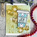Card with the cup colored pink and blue on a gold embossed word background, gold foliage and red beads around it, sentiment "JOY peace & comfort."