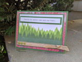 Soft card with pale layered pines behind a small centered sentiment.