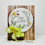 Card with the colored wreath on a woodgrain background, 'happy birthday.'