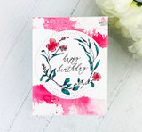 Card with the wreath in pinks over a magenta wash, 'happy birthday.'
