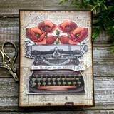 Card on wood grain paper with vintage scissors, a typewriter stamped and colored in grey with red poppies blooming from the carriage, and "I love the story we are writing together" on a strip.