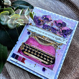 Purple and blue scalloped card with eucalyptus, a magenta typewriter with deep purple poppies, and "I love the story we are writing together" in script.