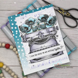 Blue and white dotted card with markers and wood beads, the typewriter colored in soft greys with pale teal poppies, and the script sentiment tucked in the corner.