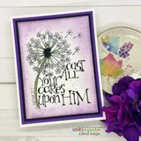 A nesting-die frame around a dandelion stamp on a purple card, 'cast all your cares upon Him.'