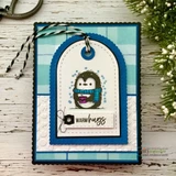 A stitched die frame around a penguin on a tag card, 'warm hugs.'