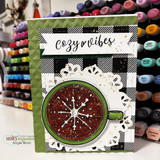 Winter card with the buffalo-check background and a steaming cocoa mug topped by a snowflake, tagged 'Cozy vibes.'