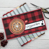 A slimline card in red and black buffalo check with a stamped compass medallion in a circle and a small cozy vibes label, photographed with alcohol markers.