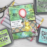 Balloon Pooh over a green distress-ink collage background flanked by Distress Oxide pads.