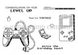 Line-art stamp sheet of retro game controllers and a handheld console with sentiments 'congratulations on your level up,' 'enjoy the birthday loot' and 'you're vintage.'