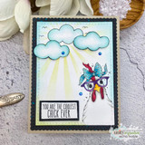 Chicken in a bow and glasses under stamped clouds and sun rays on a navy-framed coolest-chick card.