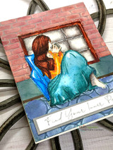 Handmade card featuring the AngieGirl curled at a window in a cozy blanket, in a pink blanket with a beaded accent, stamped with 'Just a note thinking of you'.