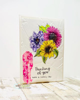 The flowers colored in bold pinks and yellow on an embossed white card — 'Thinking of you, have a lovely day.'