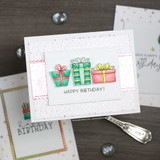 Row of colorful gifts, 'Happy Birthday!,' on a soft pink card.