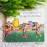 Green card with die-cut hearts and Pooh's honey jar branch, 'It is not what we have but who we have that matters' sentiment