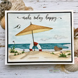 Handmade card with a serene beach scene - a straw parasol, a life ring and a little boat on the sand by gentle ocean waves and seagulls, script sentiment 'make today happy'.