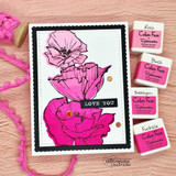 Pink card with layered poppies colored blush and magenta, a black strip reading Love you, styled beside four pink dye ink cubes.