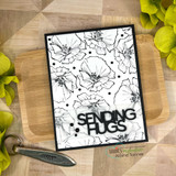 Black and white card with an all-over poppy background and bold black die-cut letters reading Sending Hugs.