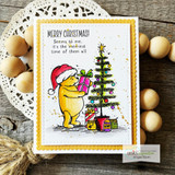 White scalloped card with a gold frame: Pooh colored yellow in a red Santa hat decorating a green tree under “MERRY CHRISTMAS! Seems to me, it's the merriest time of them all.”