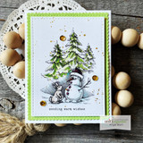 Christmas card with a snowman and a little bunny beneath snowy pine trees, over 'sending warm wishes.'