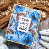 Blue-flowered card with the newsprint background and 'SENDING LOTS OF HUGS'
