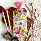 Vintage tag with colored blooms over the newsprint background and a 'wish' label