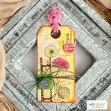 Tag card of a pink ranunculus over aged script and postage.