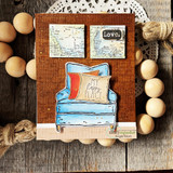 Kraft card with a blue armchair, map-print pillow and 'Love' with 'my happy place.'