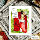 Green mixed-media card with a red stocking, a rabbit peeking out and stamped North Pole postmarks under “heartfelt holiday wishes.”