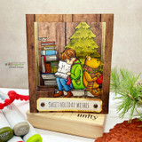 Winnie the Pooh and Christopher Robin read together by a Christmas tree with 'I can already feel the Merry,' a red rubber holiday stamp on a card.