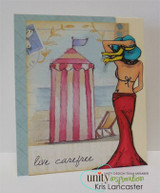The beach woman in red beside a striped beach cabana with 'live carefree.'