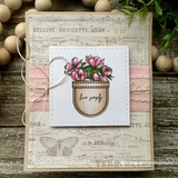 Card with the floral pocket colored soft pink over vintage sheet-music paper: 'live simply.'