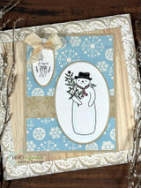 Blue snowflake card of a snowman in a black hat holding greenery, 'Peace Love Joy' tag