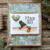 Rustic wood-framed card with a mixed-media snow panel: the snowman in a green hat with mittens beside a “stay COZY” sentiment and a heart button.