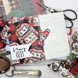 Flat-lay of plaid and sweater papers with a stamped “stay COZY” panel, scissors and a Unity key ring.
