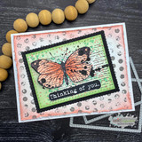 Card with an orange script-textured butterfly on a spotted background and 'Thinking of you.'