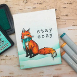 Card of the fox in a blue scarf with 'stay cozy.'